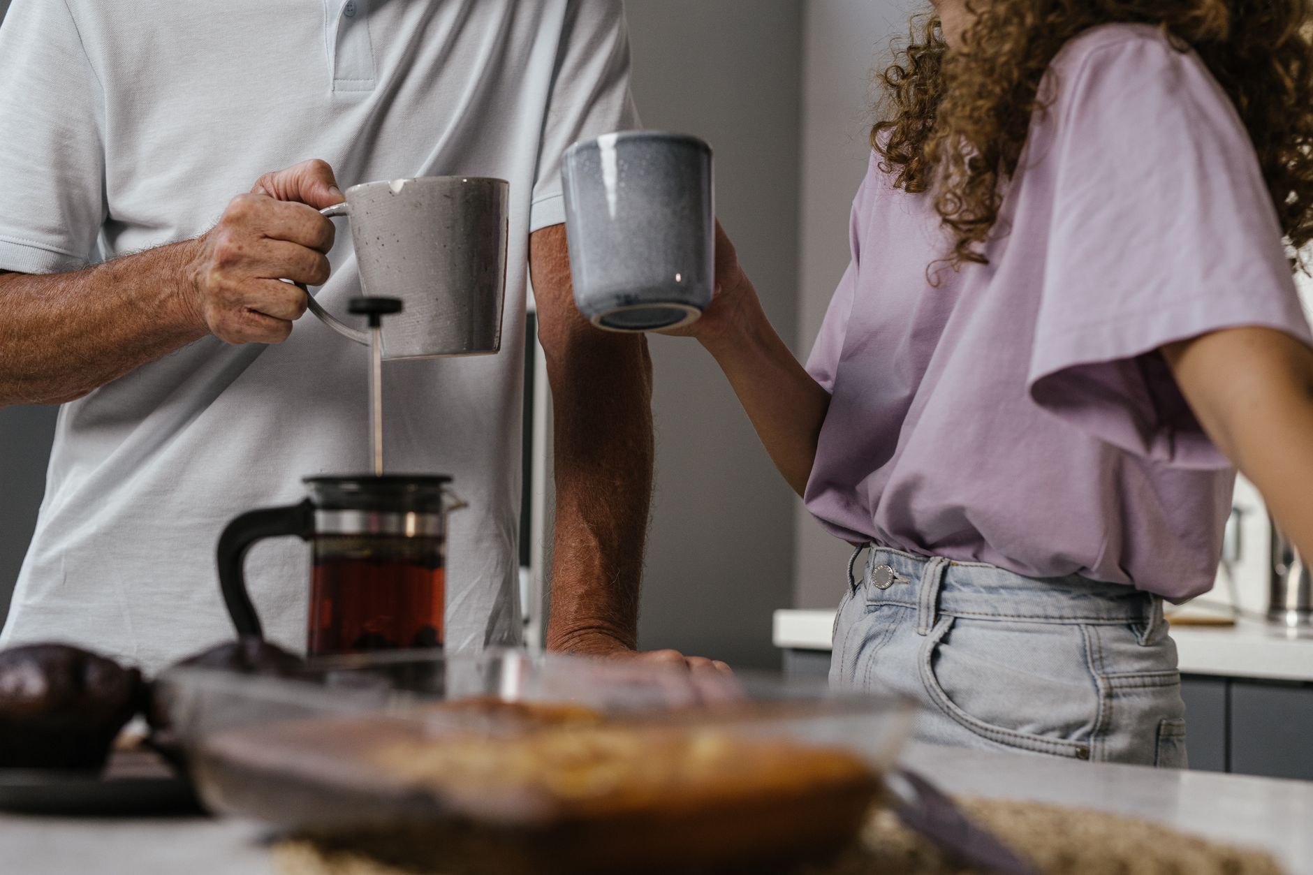 Stel drinkt samen thee aan het aanrecht, een dagelijks ritueel dat hechting en verbinding versterkt