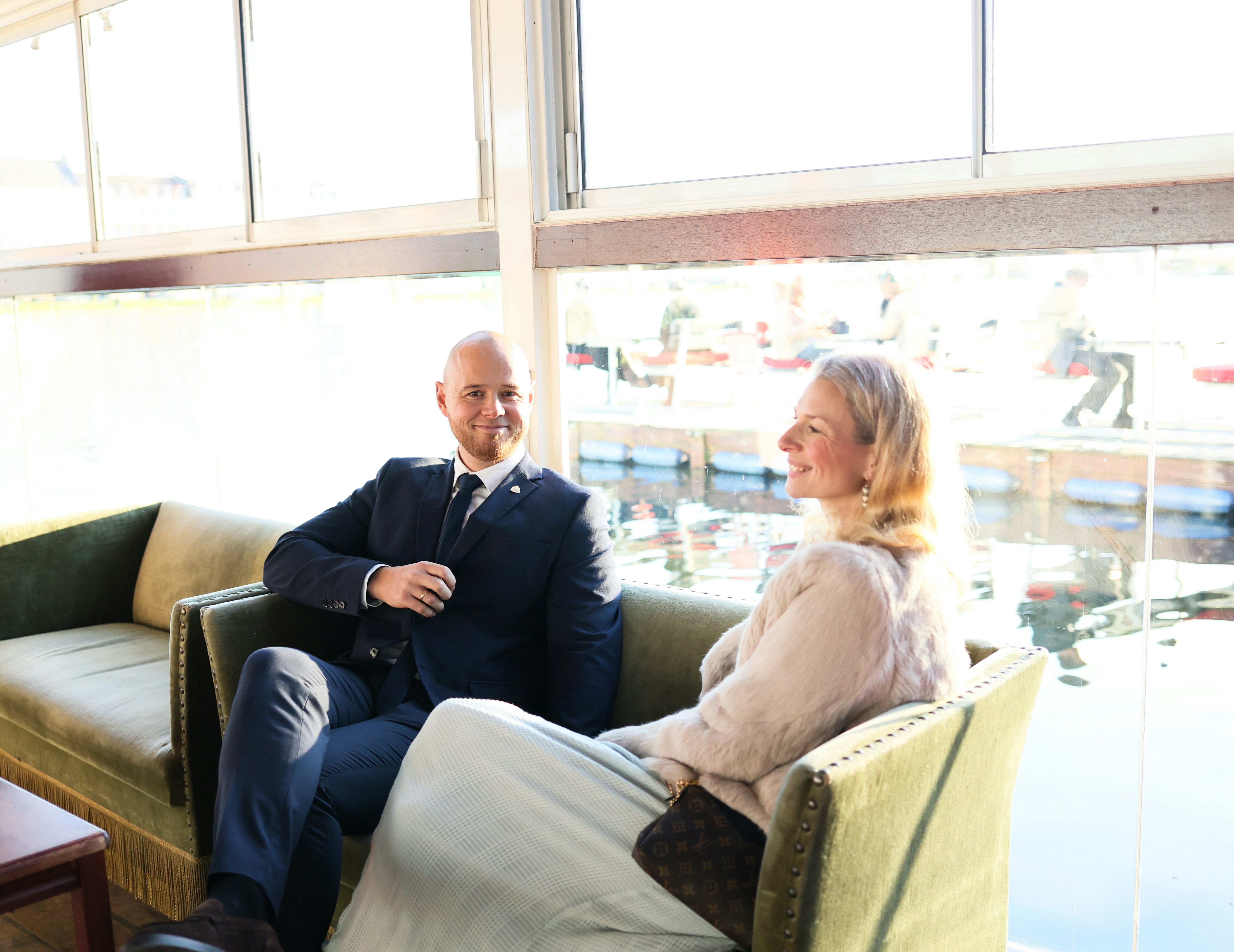 Man en vrouw praten rustig op de bank bij het raam om samen keuzes te maken