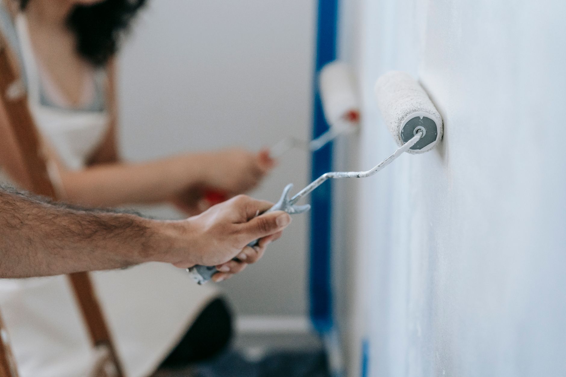 Partners schilderen samen een muur en werken als team aan hun huis